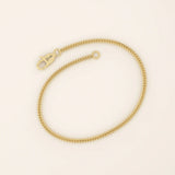 14k yellow gold bracelet with a delicate wheat chain design, polished and elegant.

