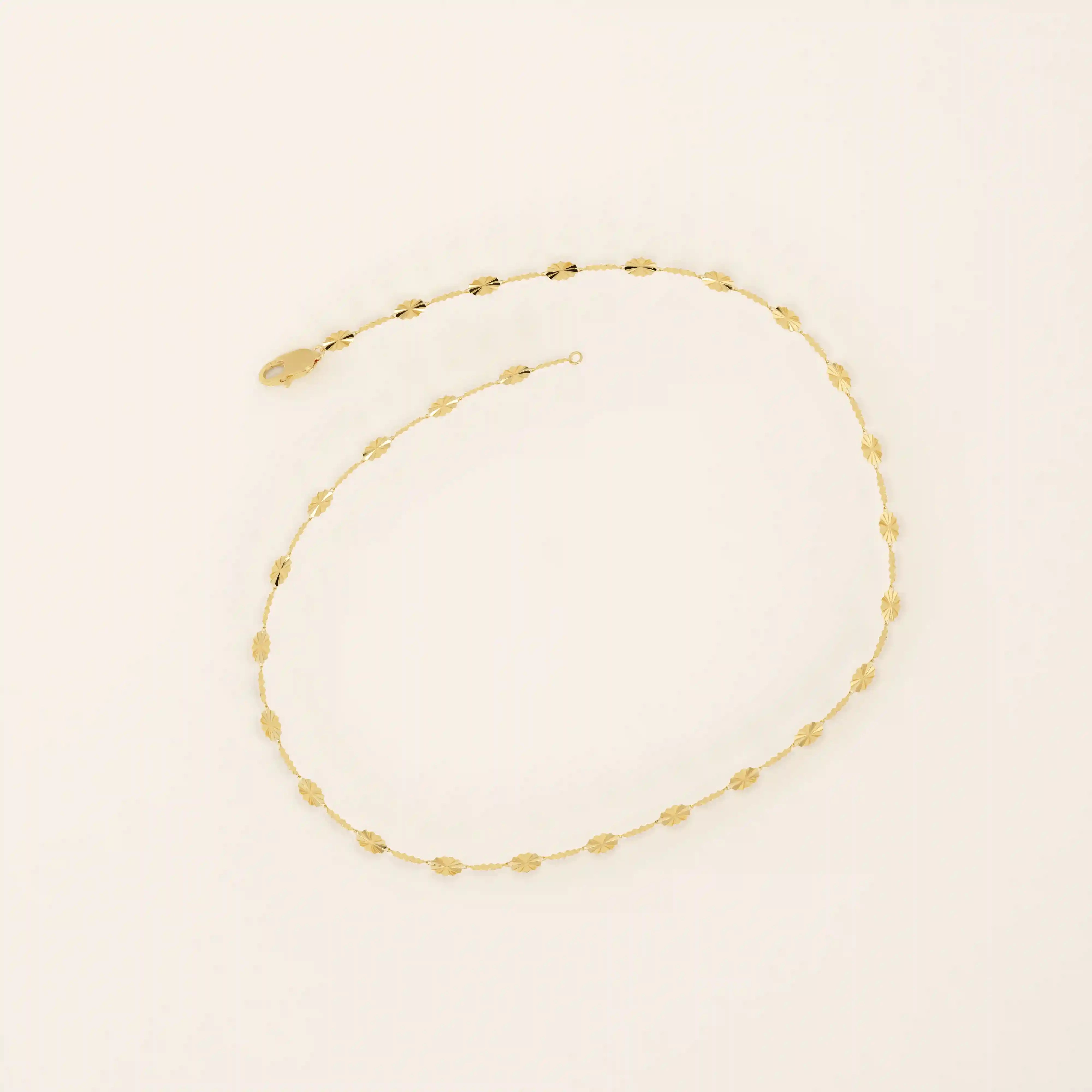 14k yellow gold bracelet with textured circular links featuring a starburst pattern.
