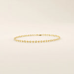 14k yellow gold bracelet with textured circular links featuring a starburst pattern.
