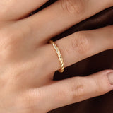 Model wearing a 14k gold vermeil twisted rope ring with a delicate braided design, adding subtle sophistication to any outfit.
