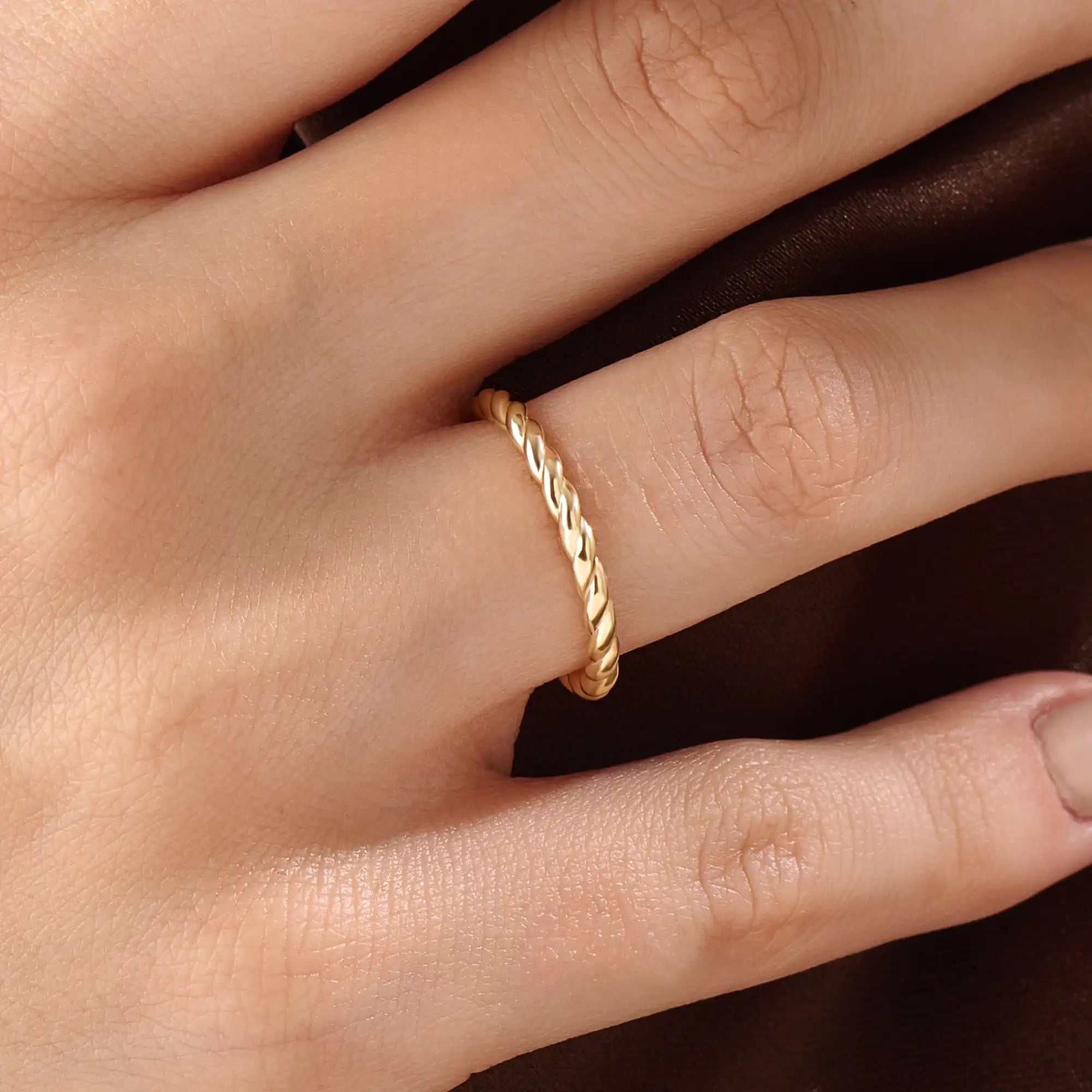 Model wearing a 14k gold vermeil twisted rope ring with a delicate braided design, adding subtle sophistication to any outfit.
