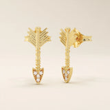 Angled view of 14k solid yellow gold arrow studs, highlighting the dimensional fletching design and the moissanite-studded arrow tip.
