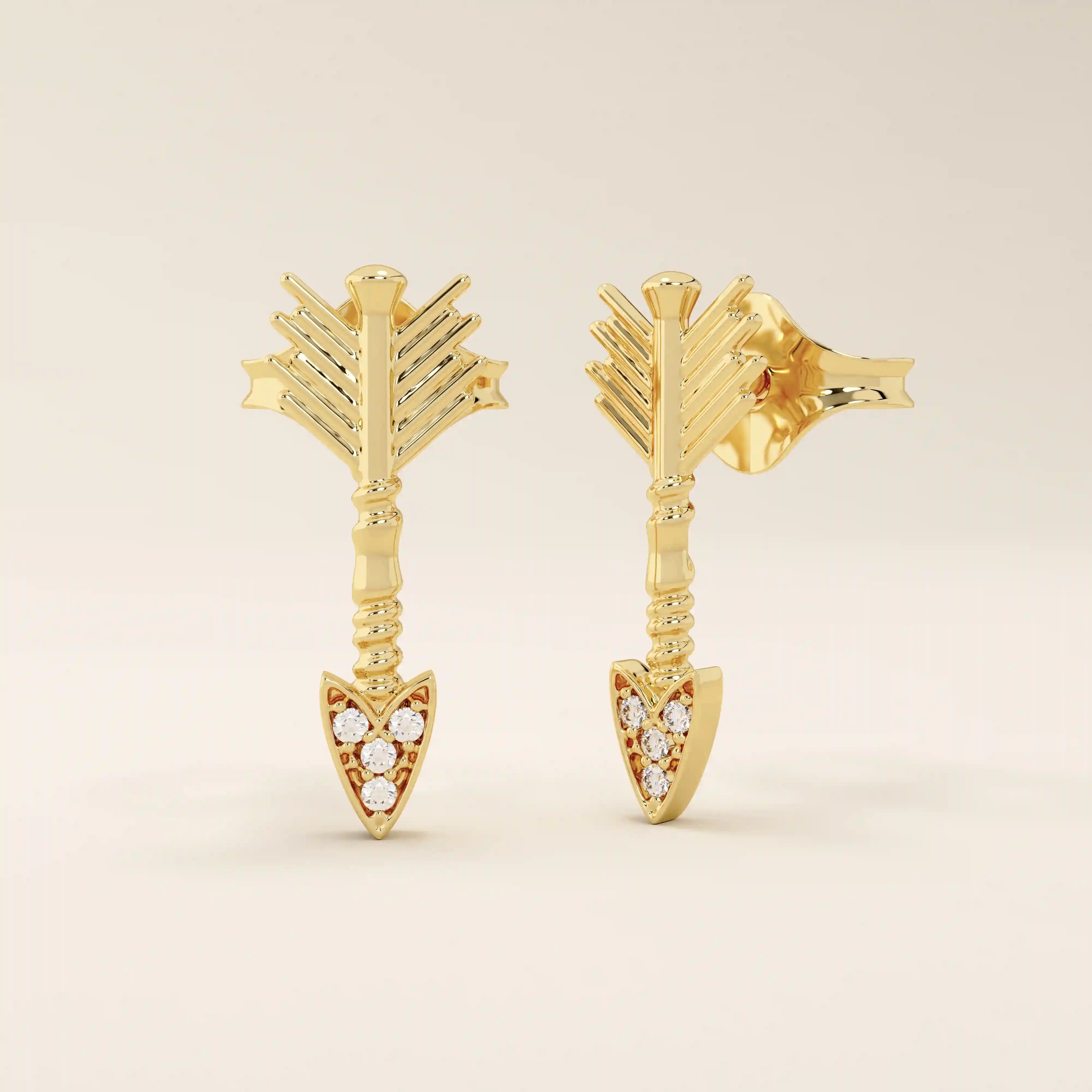 Angled view of 14k solid yellow gold arrow studs, highlighting the dimensional fletching design and the moissanite-studded arrow tip.
