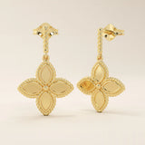 Angled view of 14k solid yellow gold dangle clover studs, highlighting the twisted post and intricate beaded border on each petal.
