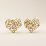Angled view of 14k solid yellow gold heart studs, showing the intricate mix of baguette and round white moissanite stones for depth and shimmer.
