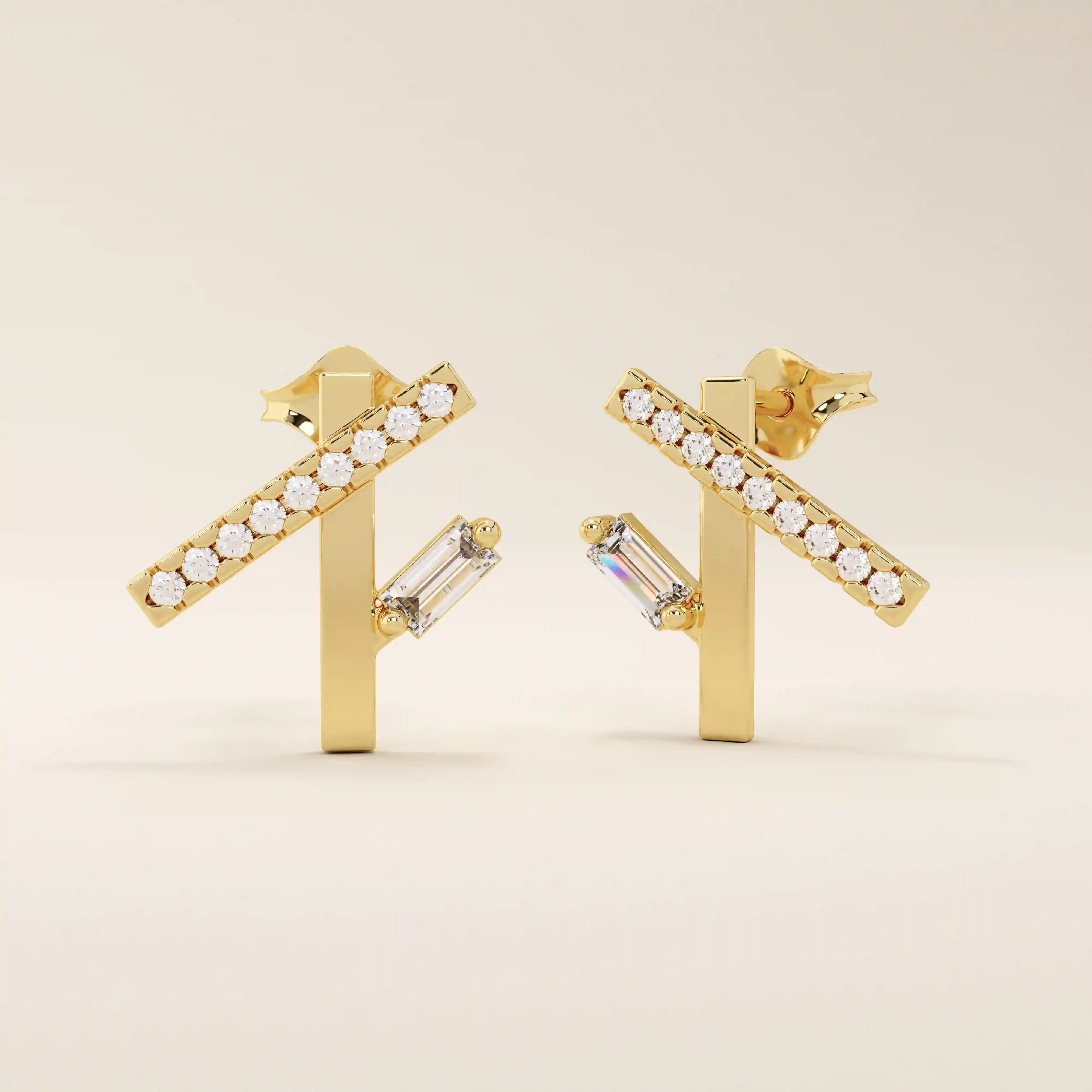 Angled view of 14k yellow gold asymmetrical bar stud earrings with pavé moissanite and a vertical baguette-cut stone detail.
