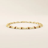 Angled view of a 14k yellow gold bone bracelet highlighting its thick, sculpted links with a glossy curved finish.
