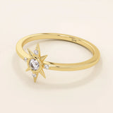 Angled view of a 14k yellow gold starburst ring, highlighting its radiant moissanite center and delicate side stones.

