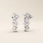 Baguette cluster stud earrings in 14k white gold with alternating baguette and round stones in a modern clustered pattern.
