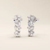 Baguette cluster stud earrings in 14k white gold with alternating baguette and round stones in a modern clustered pattern.

