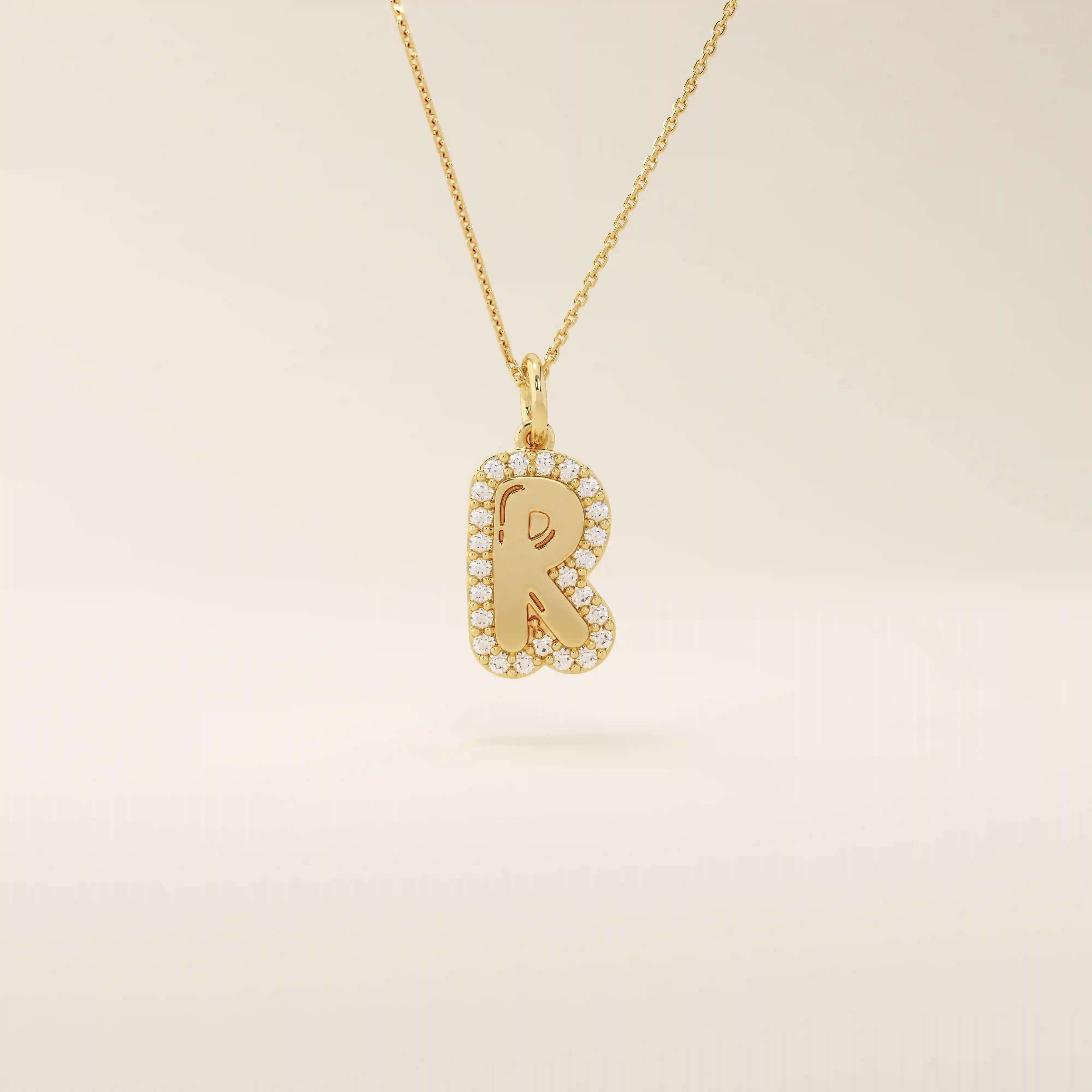 Bubble font initial pendant in 14k solid gold, framed with a halo of shimmering moissanites. A bold yet playful personalized necklace.