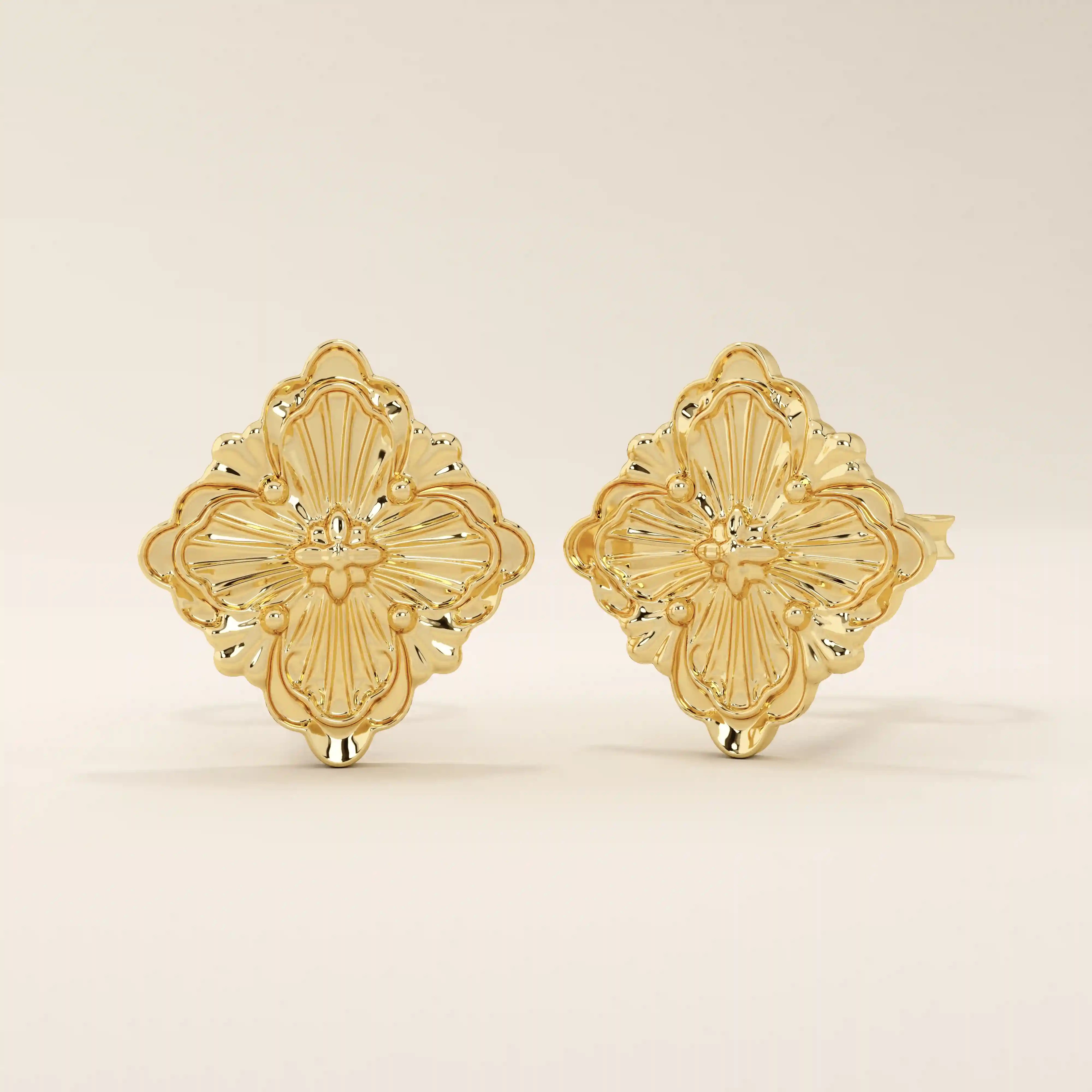 Close-up of 14k gold clover-shaped stud earrings showing embossed floral textures and intricate detailing.
