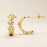 Close-up of 14k gold knot stud earrings highlighting the twisted rope design and moissanite accents.
