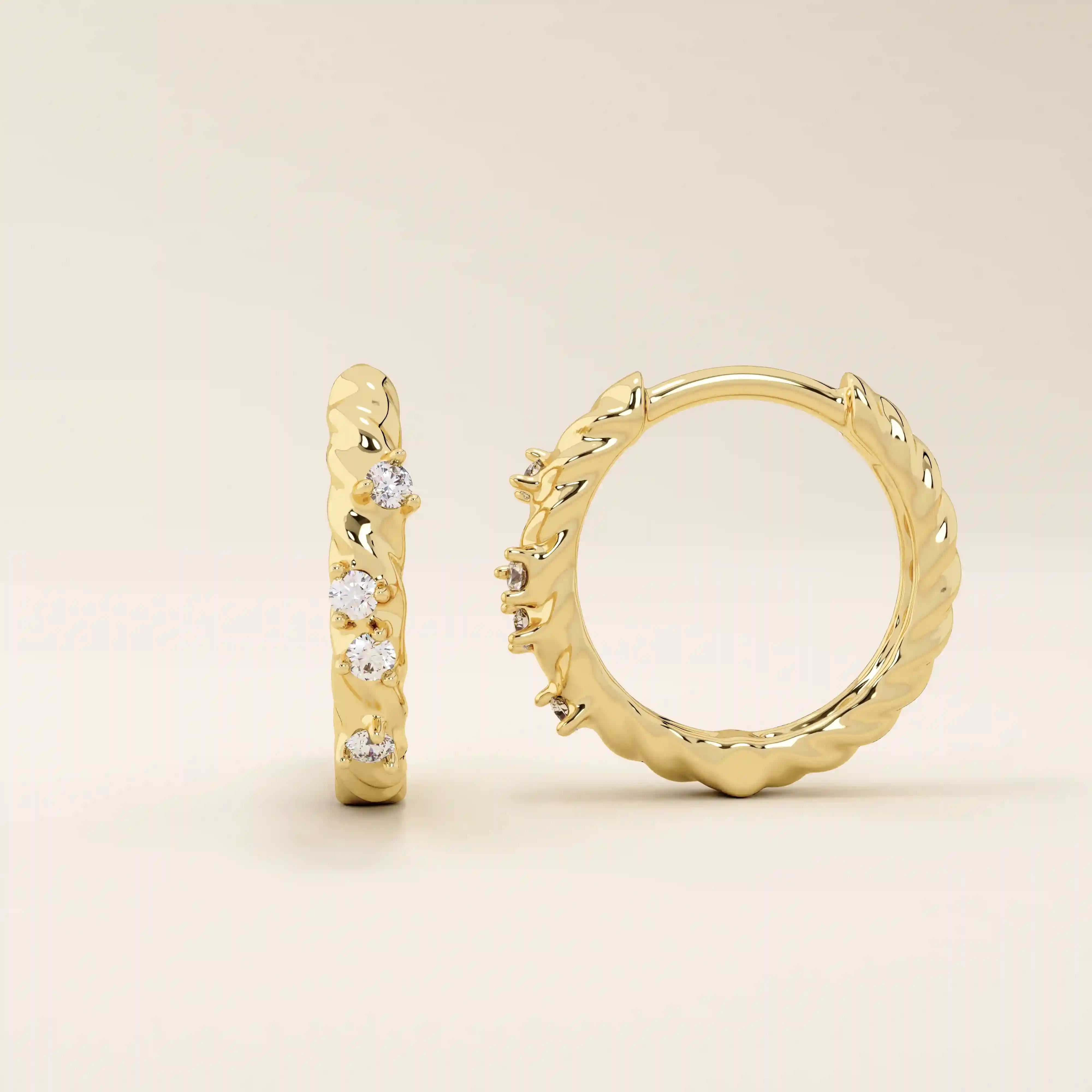 Close-up of 14k gold twist rope hoop earrings featuring moissanite stones along the braided design.
