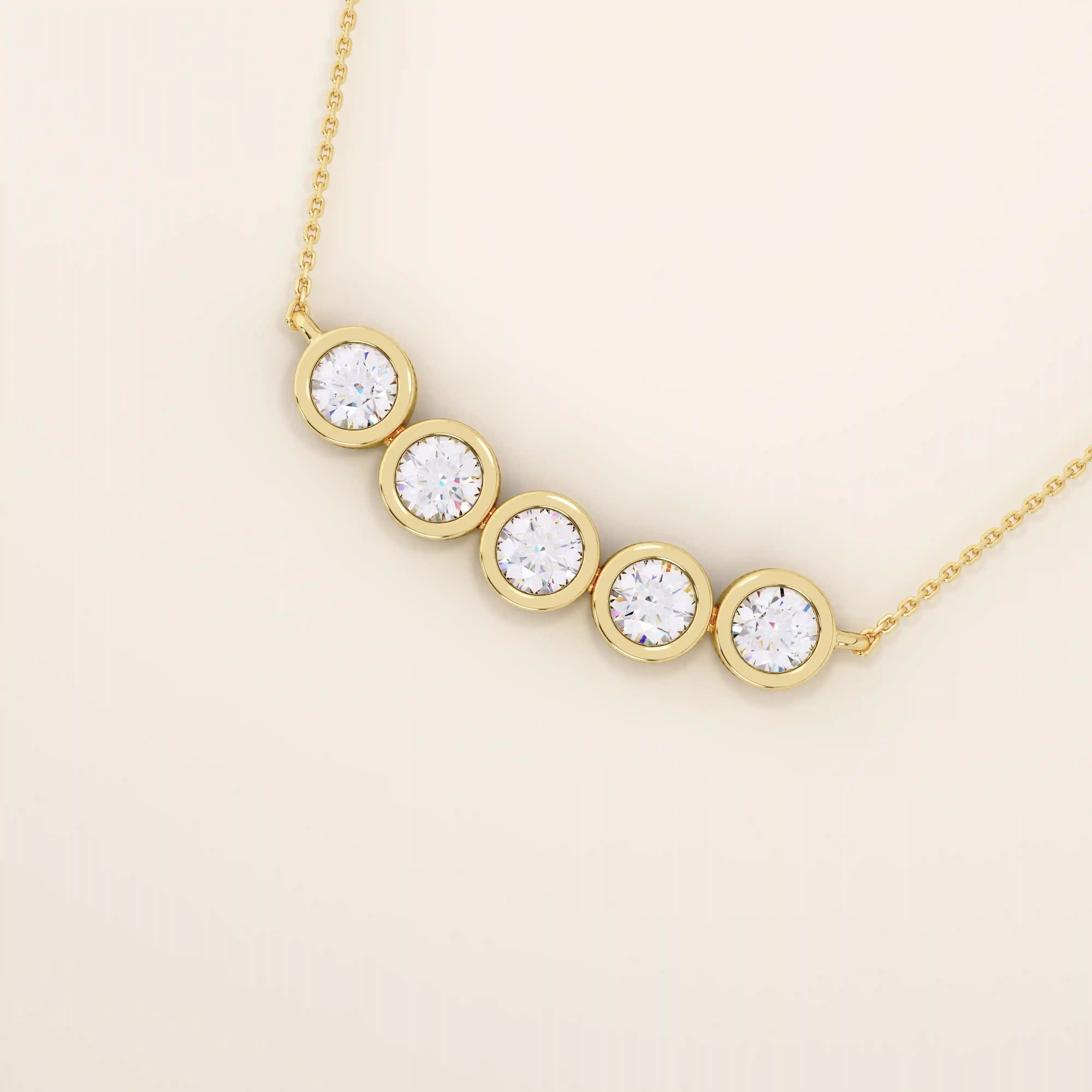 Close-up of 5 stone bezel necklace in polished 14k gold, highlighting the smooth circular settings and brilliant stones.
