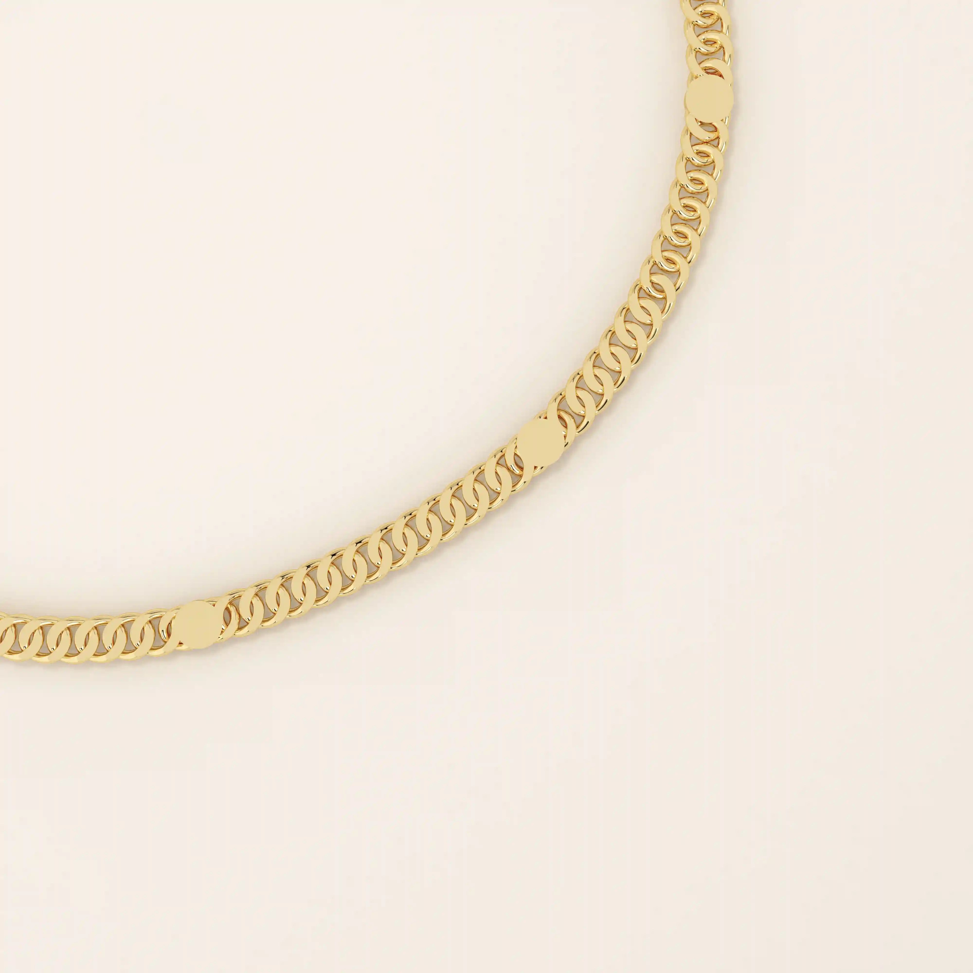 Close-up of a 14k gold bracelet showing interlocking curb links with polished round disc accents.
