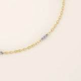 Close-up of a 14k gold bracelet with oval chain links and faceted mixed-metal bar accents for added shine.
