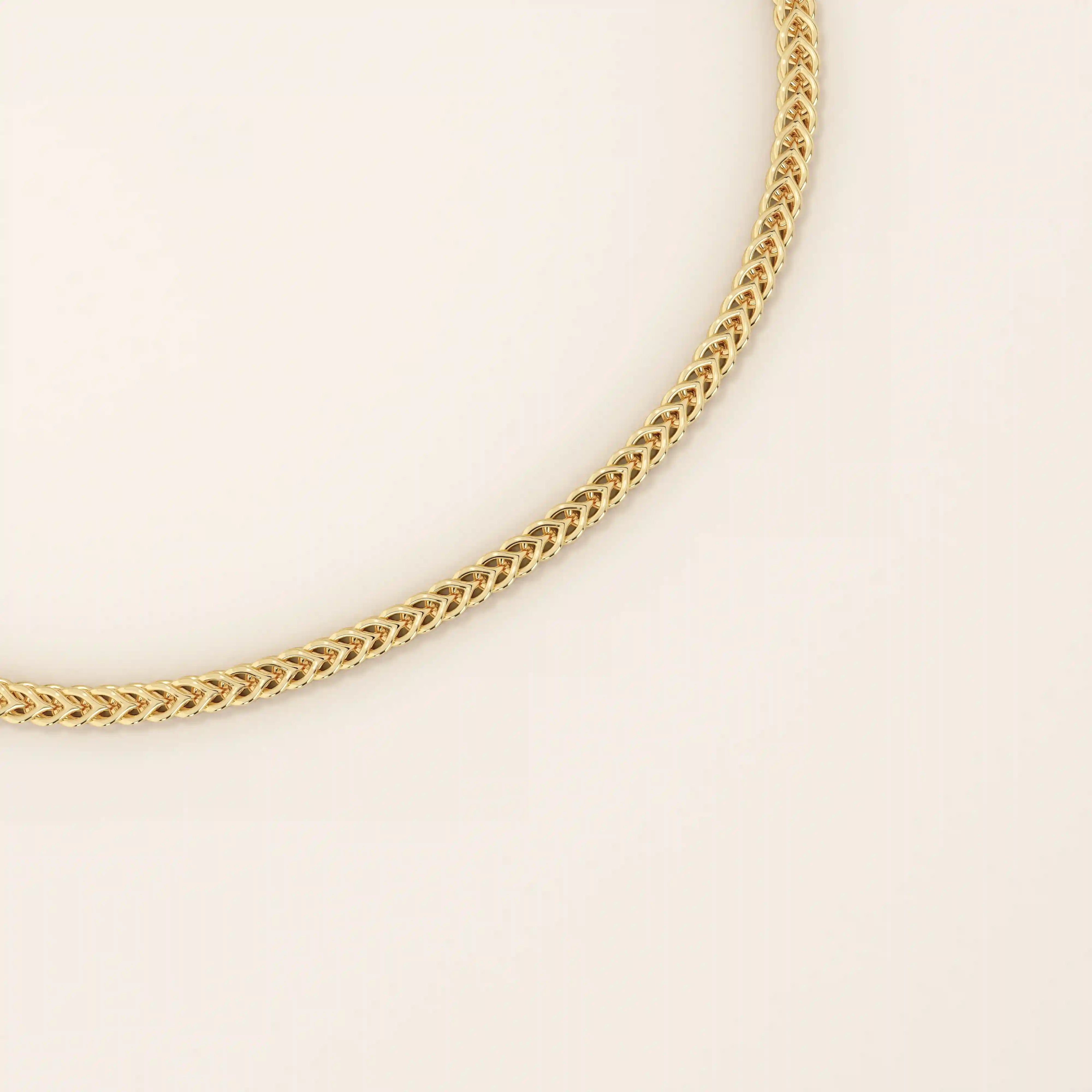 Close-up of a 14k gold wheat chain bracelet showing the intricate braided link design.
