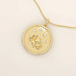 Close-up of a 14k solid gold pendant necklace featuring an embossed water lily and a tiny moissanite. Dainty nature-inspired jewelry for women. Ideal as a minimalist everyday gold necklace.