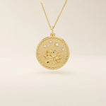 Close-up of a 14k solid gold pendant necklace featuring an embossed water lily and a tiny moissanite. Dainty nature-inspired jewelry for women. Ideal as a minimalist everyday gold necklace.