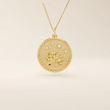 Close-up of a 14k solid gold pendant necklace featuring an embossed water lily and a tiny moissanite. Dainty nature-inspired jewelry for women. Ideal as a minimalist everyday gold necklace.