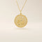 Close-up of a 14k solid gold pendant necklace featuring an embossed water lily and a tiny moissanite. Dainty nature-inspired jewelry for women. Ideal as a minimalist everyday gold necklace.