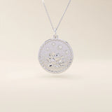 Close-up of a 14k solid white gold pendant necklace featuring an embossed water lily and a tiny moissanite. Dainty nature-inspired jewelry for women. Ideal as a minimalist everyday gold necklace.