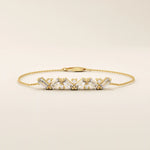 Close-up of a 14k yellow gold baguette bar bracelet highlighting the alternating baguette-cut stones and round stones.
