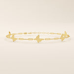 Close-up of a 14k yellow gold butterfly bracelet highlighting the polished butterfly charms and rectangular chain links.

