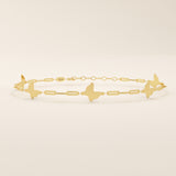 Close-up of a 14k yellow gold butterfly bracelet highlighting the polished butterfly charms and rectangular chain links.
