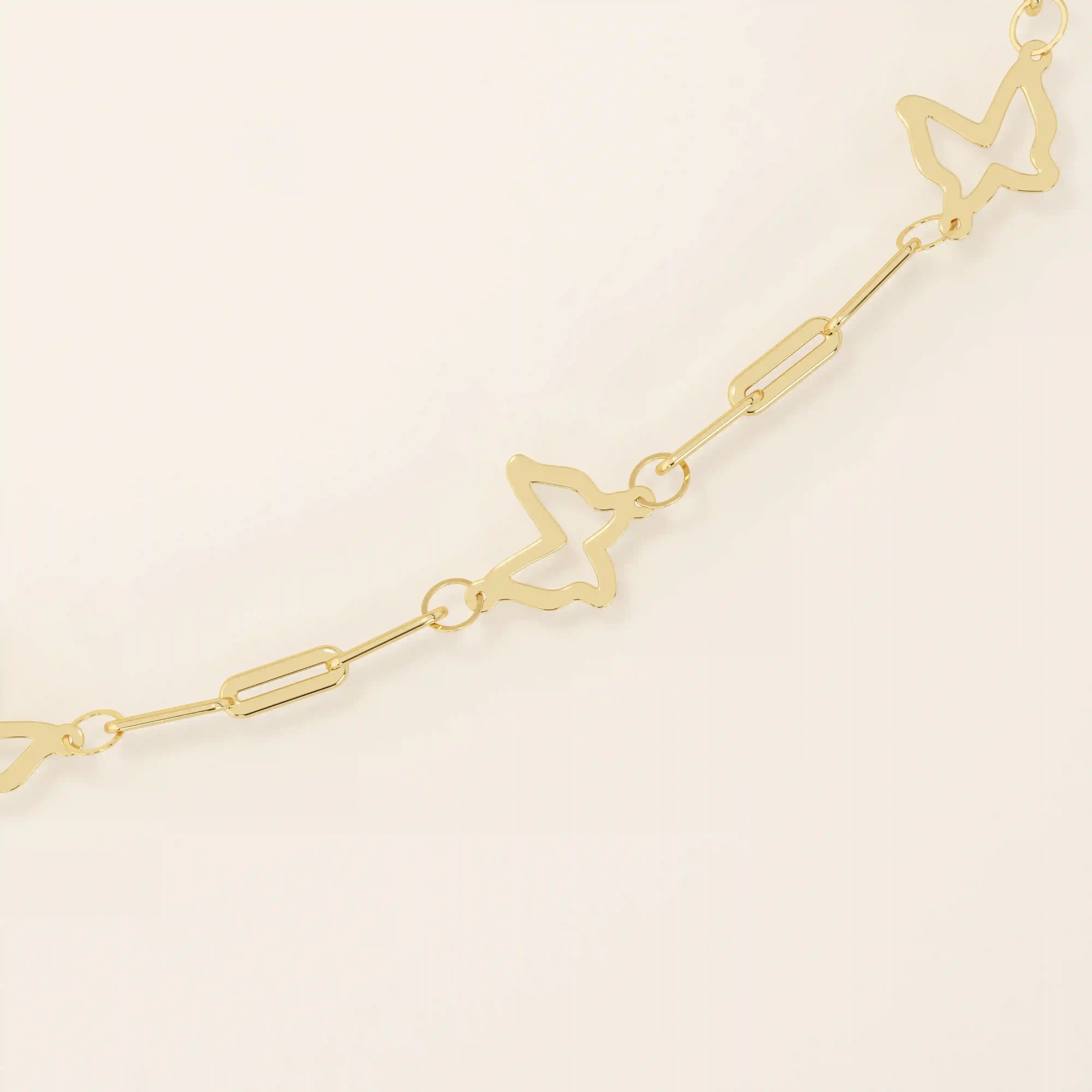 Close-up of a gold chain bracelet with butterfly-shaped cutout charms and fine elongated links.
