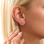 Close-up of a model wearing a 14k solid yellow gold fan stud earring, the moissanite stones catching the light for a glamorous, art deco-inspired look.
