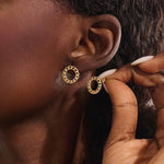 Close-up of a model wearing a 14k solid yellow gold round curb chain stud earring, highlighting its bold circular form and lustrous links.
