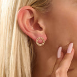 Close-up of a model wearing a 14k solid yellow gold round curb chain stud earring, highlighting its bold circular form and lustrous links.
