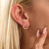 Close-up of a model wearing a 14k solid yellow gold round curb chain stud earring, highlighting its bold circular form and lustrous links.
