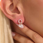 Close-up of a model wearing a 14k yellow gold pavé-set circle stud earring with three moissanite drop charms.
