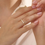 Close-up of a woman wearing a 14k solid yellow gold band with clusters of round brilliant cut moissanite stones in prong settings, sparkling and sophisticated wedding or anniversary ring
