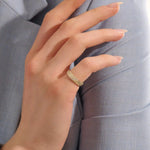 Close-up of a woman wearing a 14k solid yellow gold dome band with rows of pavé set round brilliant cut moissanite stones, luxurious and elegant wedding or statement ring
