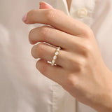 Close-up of a woman wearing a 14k solid yellow gold eternity band with sideways pear cut moissanite stones and pavé set round moissanite accents, ornate and elegant wedding jewelry
