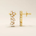 Close-up of baguette cluster stud earrings in polished 14k gold, highlighting the geometric contrast of baguette and round stones.
