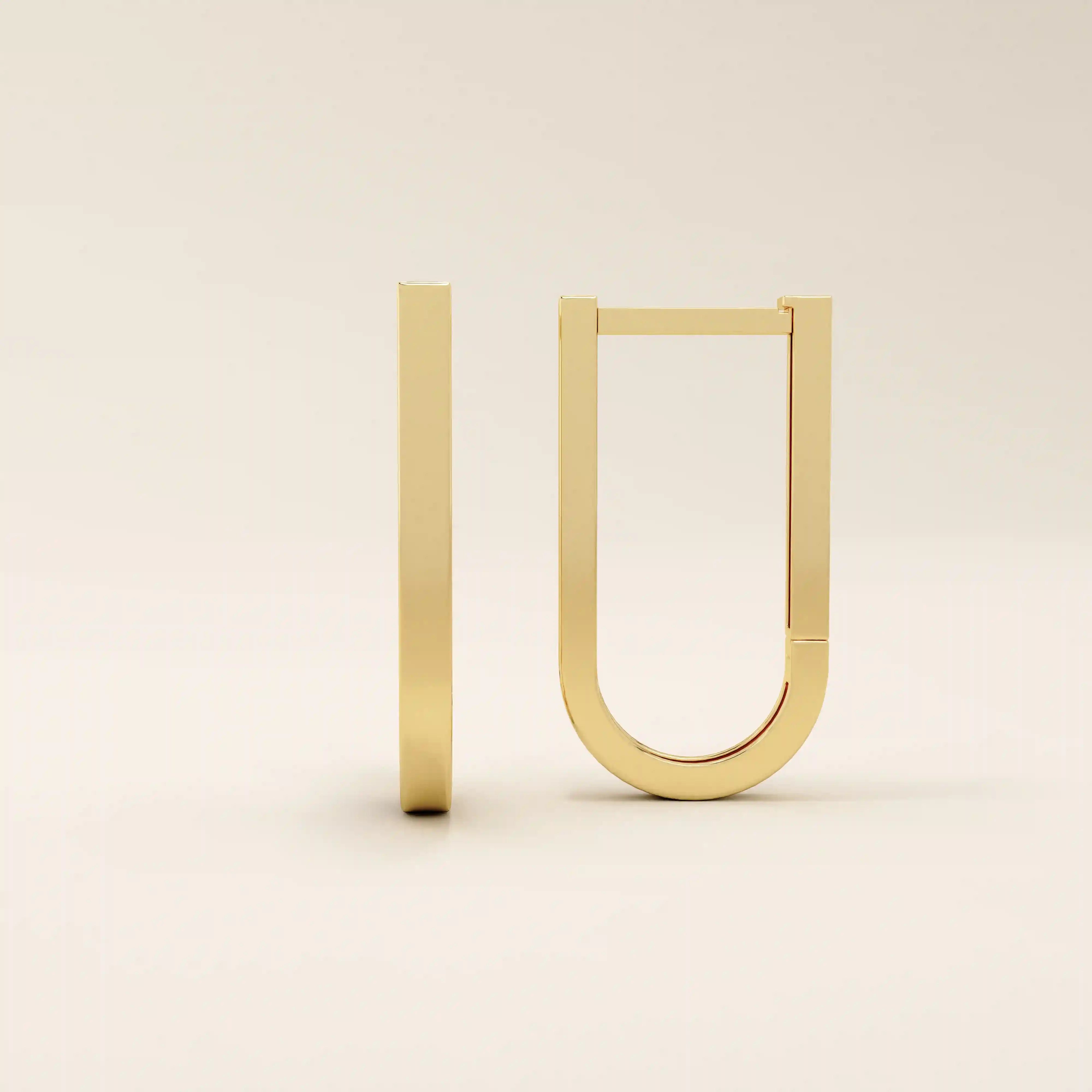 Close-up view of geometric U-shape hoop earrings in 14k gold with a smooth polished surface.
