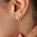 Model wearing 14k gold vermeil rectangle hoop earrings that highlight their clean, sculptural lines and lustrous golden sheen — ideal for modern everyday style.
