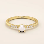Delicate 14k solid gold promise ring featuring a small lustrous pearl. Minimalist and elegant design perfect for everyday wear.