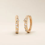 Elegant twist rope hoop earrings in 14k rose gold with moissanite accents.

