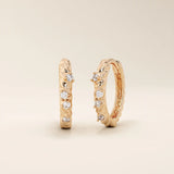 Elegant twist rope hoop earrings in 14k rose gold with moissanite accents.
