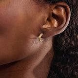 Model wearing 14k gold knot stud earrings, displaying the twisted rope detail and moissanite embellishment on the earlobe.
