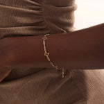 Model wearing a 14k gold butterfly bracelet with open butterfly charms and lightweight chain design.
