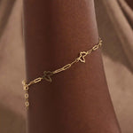 Model wearing a 14k gold butterfly bracelet with open butterfly charms and lightweight chain design.

