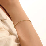 Model wearing a 14k gold rolo chain bracelet, showcasing the interlocking rectangular link design on the wrist.
