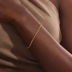 Model wearing a 14k gold rolo chain bracelet, showcasing the interlocking rectangular link design on the wrist.
